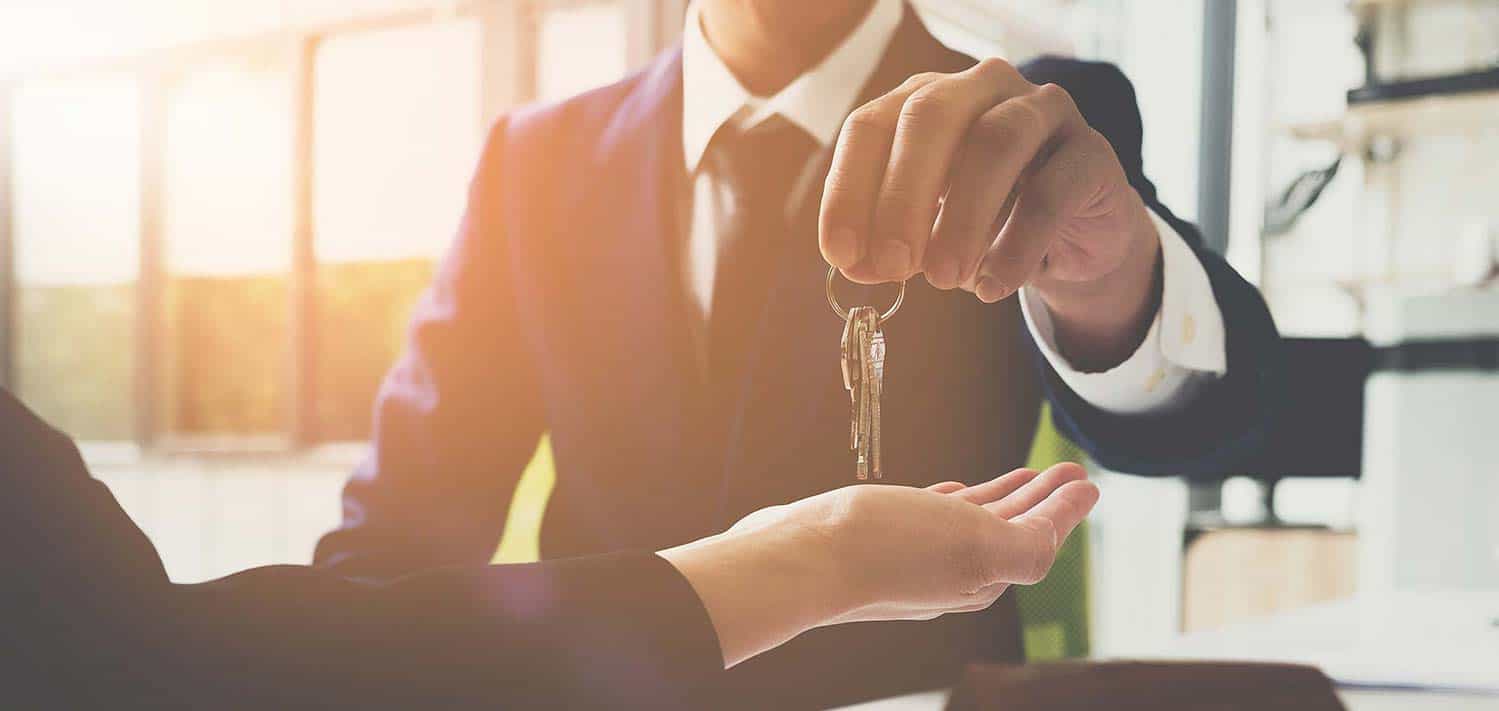 real estate agent handing keys to successful homeowner