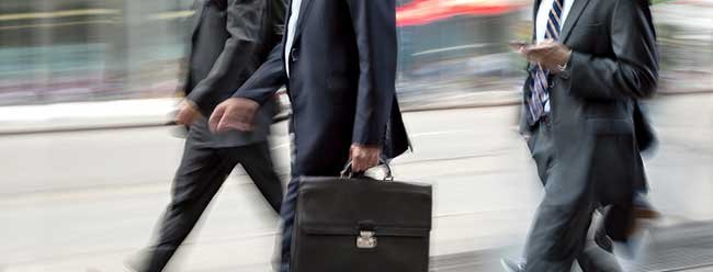 three businessmen walking with a briefcase