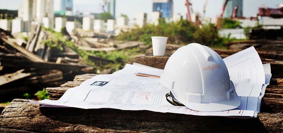 construction site with papers and helmet on wooden platform