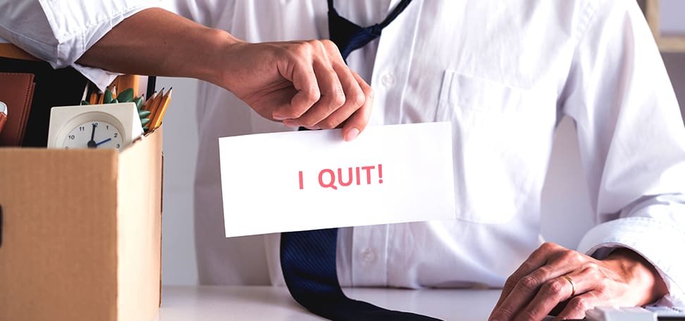 worker holding a paper with I quit written on it
